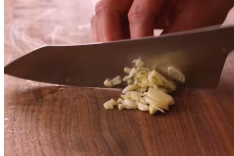 Minced fresh garlic cloves and prepped ingredients for homemade Chicken Alfredo