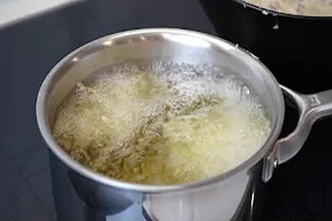 Frying chicken pieces in a hot skillet until golden and crispy
