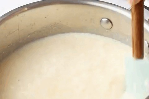 Cooking the shredded coconut flakes with milk and cornstarch in a saucepan