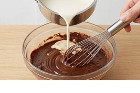 Simmering dark chocolate fudge sauce in a small saucepan