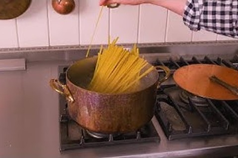 Boiling fettuccine pasta in a large pot of salted water