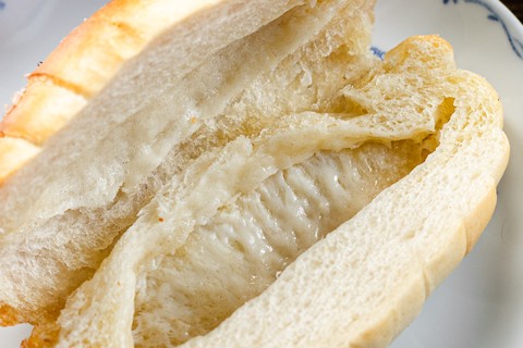 Salt bread roll cut in half showing the hollow butter pocket