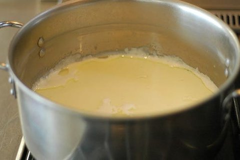 Heating milk, oil, and sugar in a saucepan for cinnamon roll dough