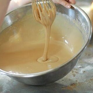 Whisking coffee maple frosting in a bowl