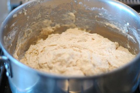 Puffy, risen cinnamon roll dough in a large bowl
