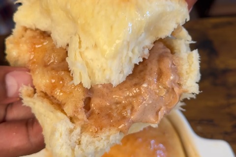Freshly baked golden Texas Roadhouse rolls brushed with butter and pulled apart warm