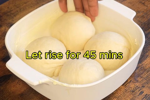 Shaped Texas Roadhouse rolls proofing and rising in a baking dish before baking